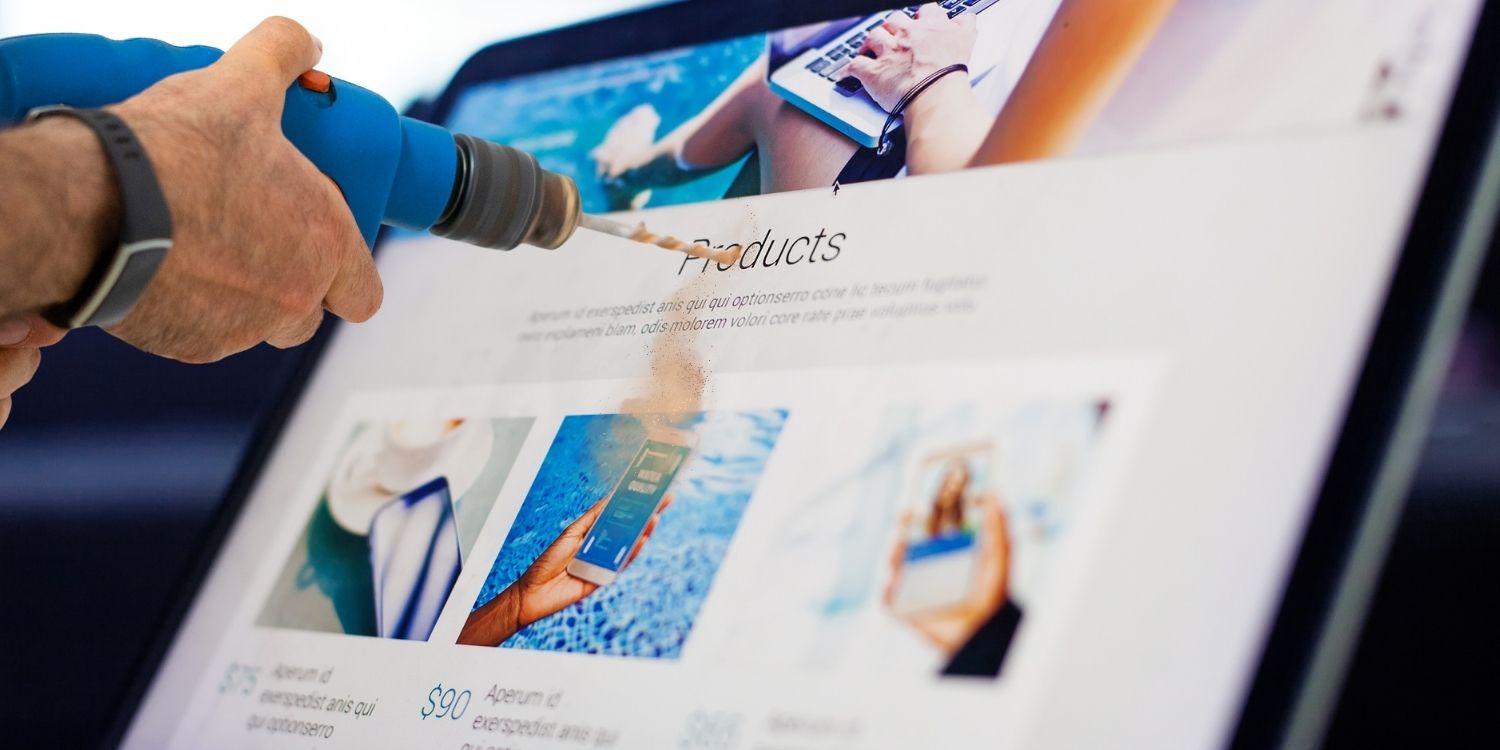 Screenshot of a man drilling a computer screen. A silly image about website maintenance.